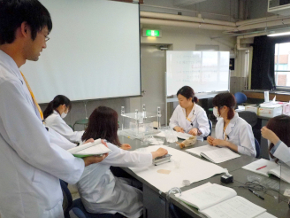 写真　学生指導員(左)による安息角測定の指導